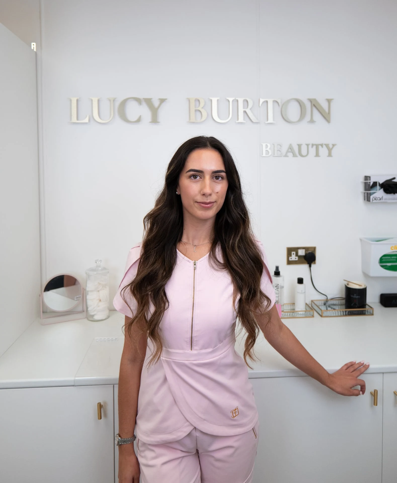 Lucy in her Holland-on-Sea studio, in front of the Lucy Burton Beauty sign